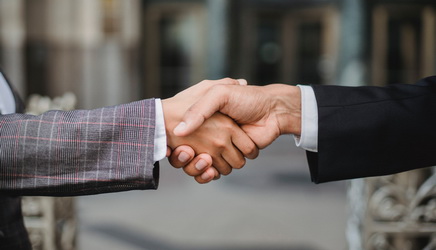 two people in professional suits shaking hands